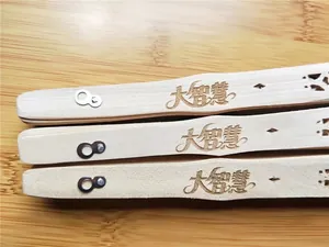 Macro close-up showing detailed laser engraved characters on a wooden folding fan handle