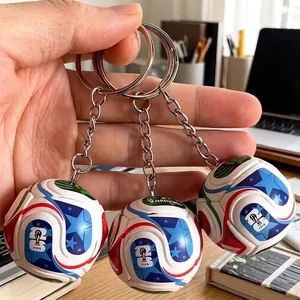 Close-up of 2026 World Cup style 3D football keychains held in hand for sports fans