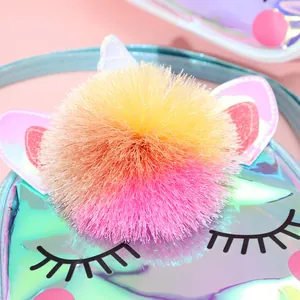 Detailed macro shot of a fluffy colorful pom-pom on a holographic unicorn kids shoulder bag