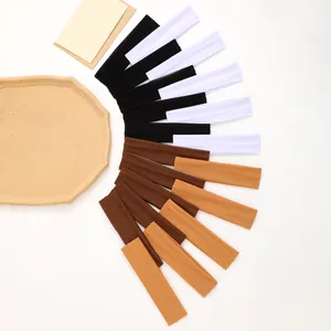 Fan-shaped arrangement of solid colored elastic headbands in black, white, and earthy tones.
