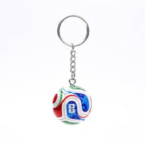 Macro detail of 3D football soccer ball keychain with vibrant tournament patterns.