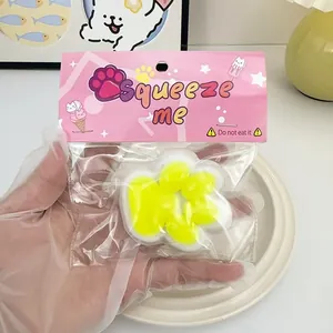 Detailed view of a neon yellow cat paw squeeze toy in packaging for stress relief