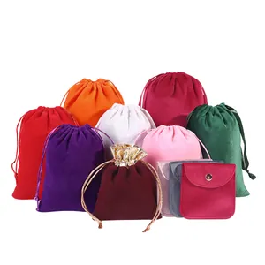 Assorted colorful velvet drawstring pouches and snap jewelry bags on white background.