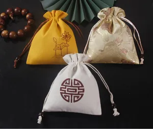 Détail des pochettes à bijoux de style chinois avec motifs de lotus et de grue