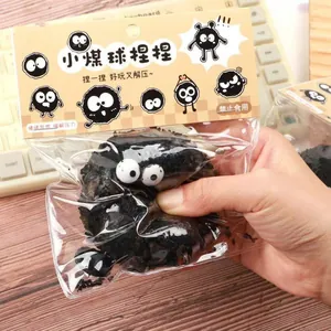 Close-up of a black soot sprite squeeze toy held in hand, packaged for stress relief