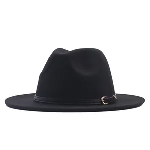 Detail of a black suede fedora hat featuring a stylish leather band and golden buckle.