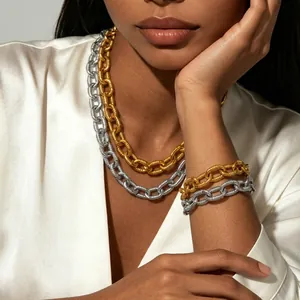 Detailed macro view of layered chunky gold and silver chain necklace with spiral texture