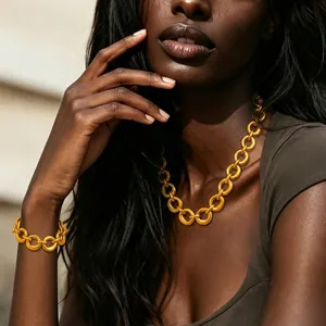 Close-up of model wearing chunky gold link necklace and matching bracelet jewelry set