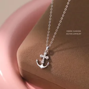 Gros plan détaillé d'un collier avec pendentif croix ancre en argent S999 et zircons
