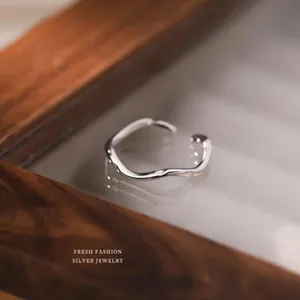 Élégante bague ouverte minimaliste en argent sterling S999 au design ondulé irrégulier.