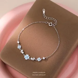 Vue détaillée d'un bracelet en argent avec fleurs en émail bleu et pierres brillantes