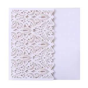 Detailed view of intricate laser-cut floral pattern on a white wedding invitation card.