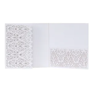 Detailed view of white laser-cut wedding invitation with intricate floral lace pattern