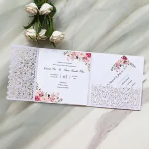 Elegant close-up view of a white laser-cut floral wedding invitation card with insert.