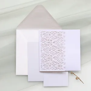 Detailed view of elegant laser-cut white wedding invitation set with envelope and cards