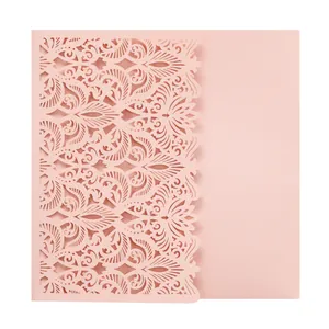 Detailed close-up of a pink laser-cut wedding invitation card with lace patterns