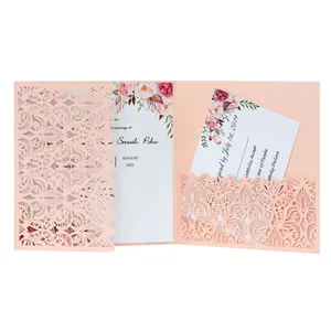 Close-up view of an elegant peach laser-cut wedding invitation card with floral details