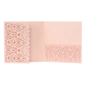 Detail view of the intricate laser-cut floral pattern on a pink wedding invitation card
