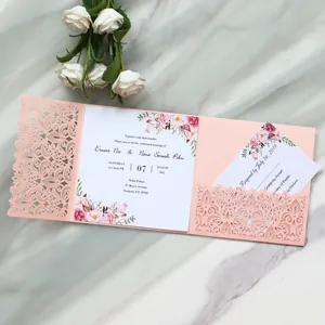 Detailed view of elegant pink laser-cut wedding invitation with floral insert card.