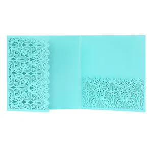 Detailed view of light blue laser-cut wedding invitation with intricate floral lace patterns