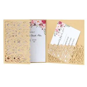 Detailed view of champagne laser-cut lace wedding invitation with floral insert card