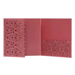 Detailed macro view of an elegant maroon laser-cut lace wedding invitation with pocket