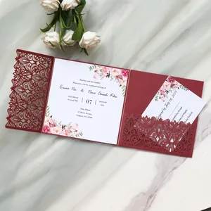 Close-up of burgundy laser-cut floral wedding invitation with floral printed inner card