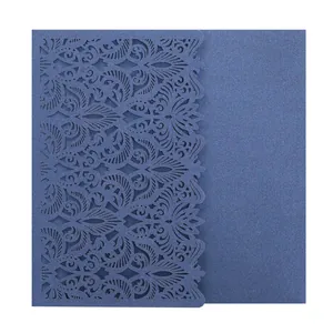 Detail view of intricate laser cut floral pattern on deep blue wedding invitation card