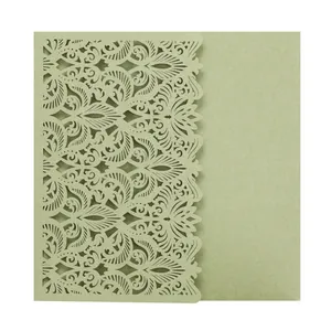 Detailed view of sage green laser-cut invitation with intricate lace patterns