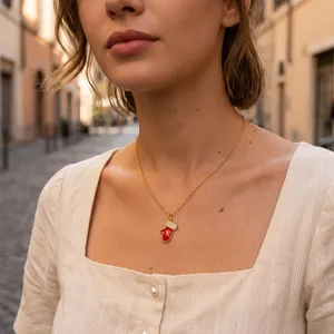 Close-up of a festive red Christmas mitten pendant necklace with micro-pave detailing on a model
