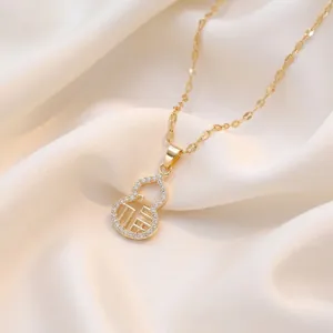 Vintage gold gourd pendant necklace with Fu character and crystal accents on silk background