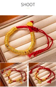 Close-up of traditional Chinese red string bracelets with sand gold beads in a box.