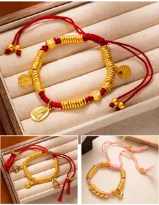Close-up of New Chinese style gold charms on adjustable red rope braided bracelets
