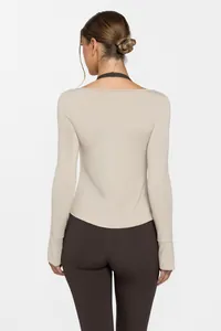 Vue arrière détaillée d'un haut de yoga beige à manches longues pour le fitness