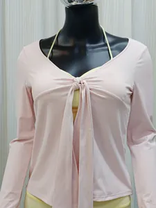 Gros plan sur le cardigan de yoga rose à manches longues avec un nœud sur le devant