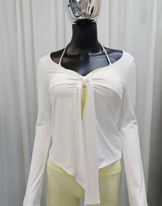 Détail d'un haut de yoga blanc avec lien à nouer et manches longues pour fitness