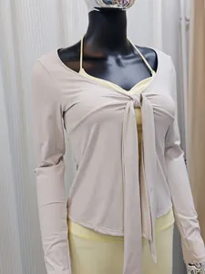 Détail d'un cardigan de yoga ajusté avec un design élégant noué sur le devant en beige.