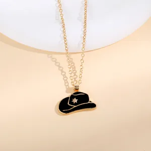 Minimalist golden chain necklace featuring a black enamel cowboy hat pendant with star
