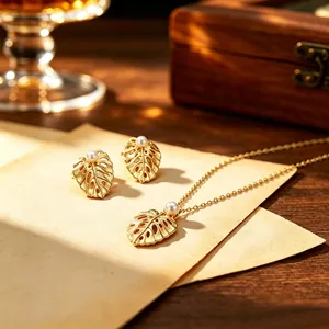 Macro view of vintage brushed monstera leaf jewelry set featuring white pearl beads
