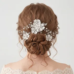 Set di forcine per capelli con fiori bianchi da sposa, perle e cristalli in uno chignon elegante