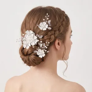 Dettaglio di forcine per capelli da sposa con fiori e perle su un'acconciatura da sposa