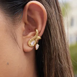 Detalle de un ear cuff de lujo en acero de titanio dorado con circonitas de pera