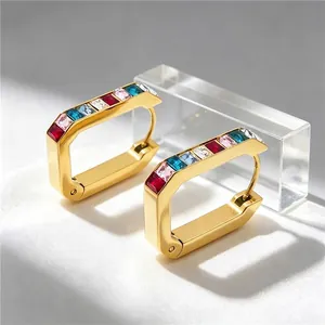 Detailed view of U-shaped gold earrings with multi-color rectangular zircons