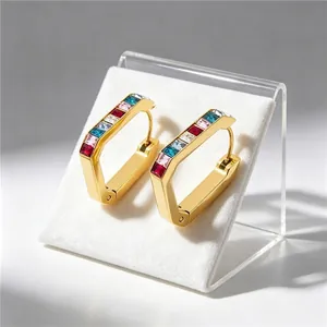 Close-up of gold-plated U-shaped earrings with multicolor square zircons in detail view