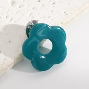 Close-up of teal hollow flower brooch for holding glasses, minimalist resin pin accessory
