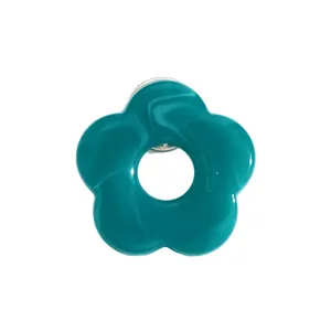 Close-up detail of a teal hollow flower brooch with a glossy finish and silver pin back