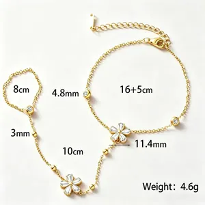 Elegante bracciale anello in acciaio dorato con fiori e dettagli in strass chiari.