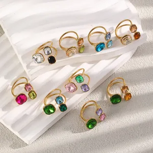 Macro view of assorted colorful geometric crystal rings with premium 18K gold plated finish.
