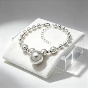 Detailed view of silver-toned chunky bead necklace featuring large central polished pendant.