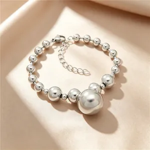 Detailed macro view of a silver titanium steel bead bracelet on champagne satin